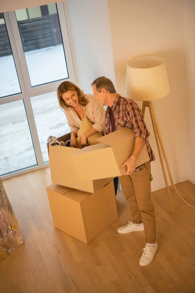 Felice coppia disimballaggio scatole di cartone a nuova casa — Foto stock
