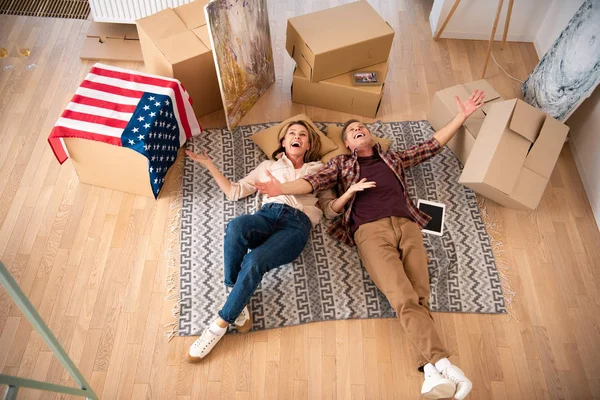 Vista aerea di felice coppia eccitato posa sul pavimento a nuova casa — Foto stock