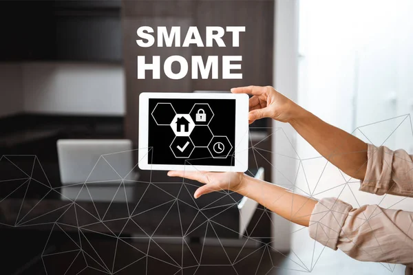 Selective focus of digital tablet with smart home icons illustration in female hands — Stock Photo