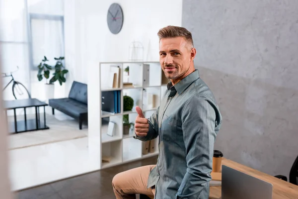 Cheerful businessman showing thumb up in modern office — Stock Photo