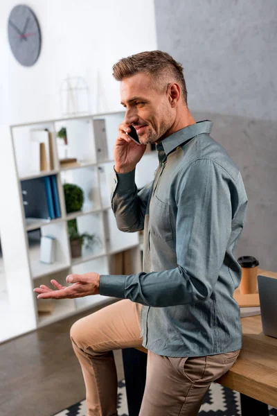 Empresário alegre conversando no smartphone no escritório — Fotografia de Stock