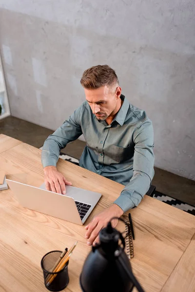 Overhead-Ansicht des Geschäftsmannes mit Laptop im modernen Büro — Stockfoto