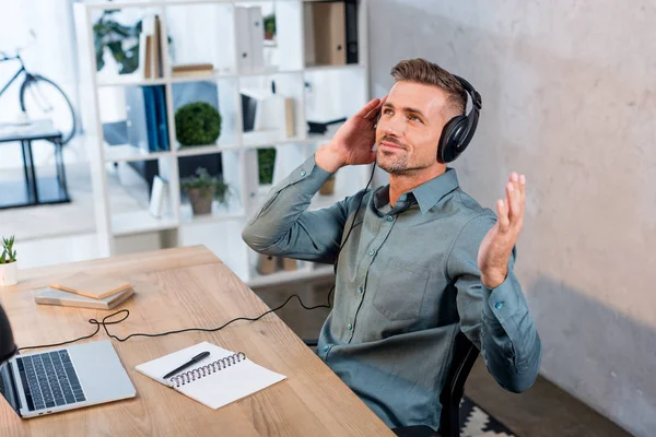 Empresário alegre ouvir música em fones de ouvido no escritório moderno — Fotografia de Stock