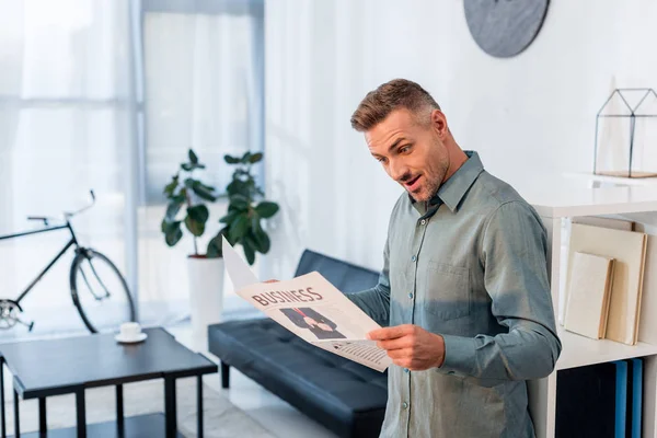 Surprised businessman reading business newspaper in modern office — Stock Photo