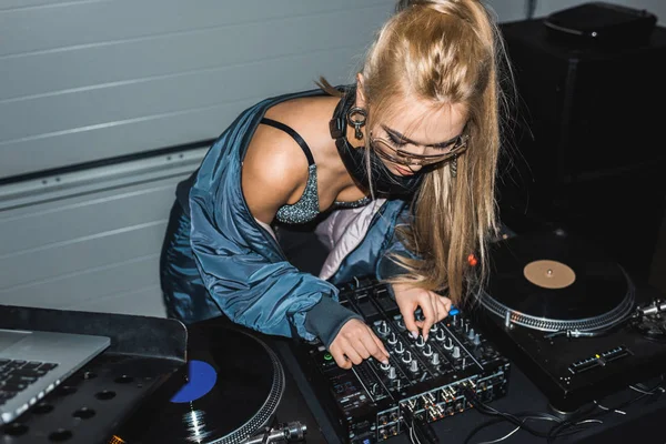 Focalisé dj femme touchant mélangeur dj et debout près de disques vinyle — Photo de stock