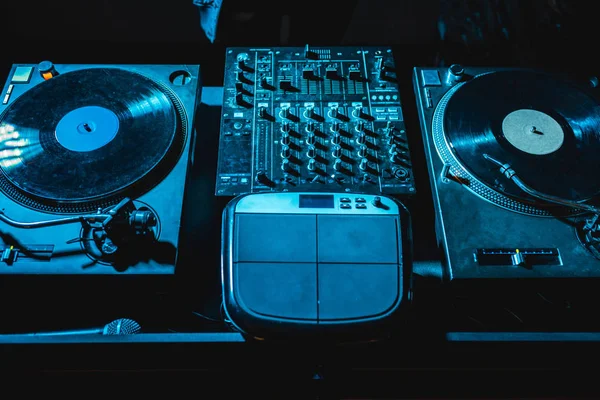 Dj mixer with equalizer and vinyl records in nightclub — Stock Photo