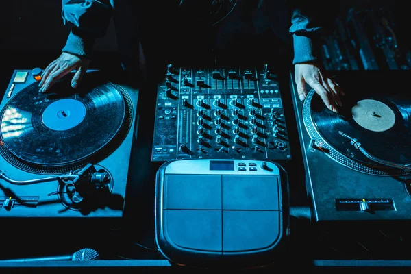 Ausgeschnittene Ansicht einer DJ-Frau, die neben einem DJ-Mischpult steht und Schallplatten berührt — Stockfoto