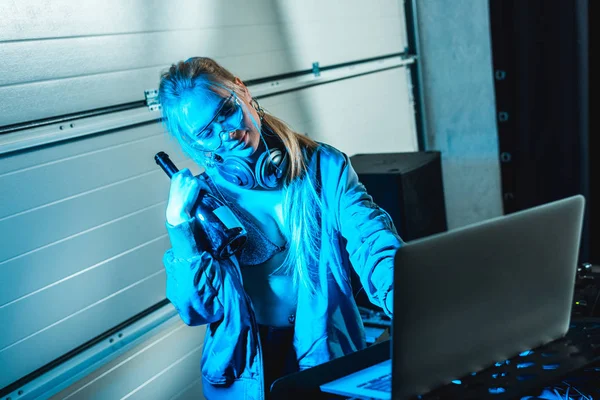 Attraktive dj Frau in Gläsern mit Flasche in der Nähe von Laptop stehen — Stockfoto