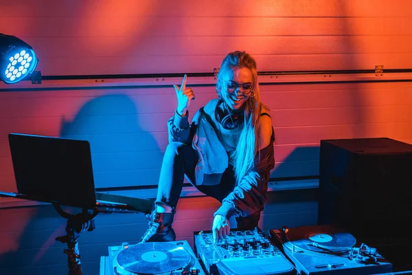 Mulher dj elegante alegre em óculos gesticulando ao tocar dj mixer — Fotografia de Stock