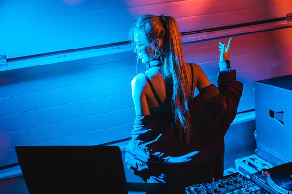 Attraktive blonde DJ-Frau gestikuliert, während sie in einem Nachtclub steht — Stockfoto