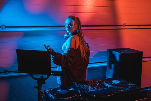 Hermosa rubia dj mujer gesto mientras de pie en discoteca - foto de stock