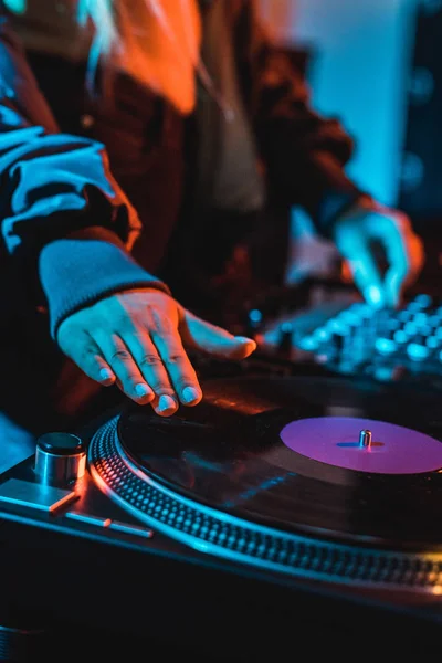 Cropped view of dj woman touching vinyl record in nightclub — Stock Photo