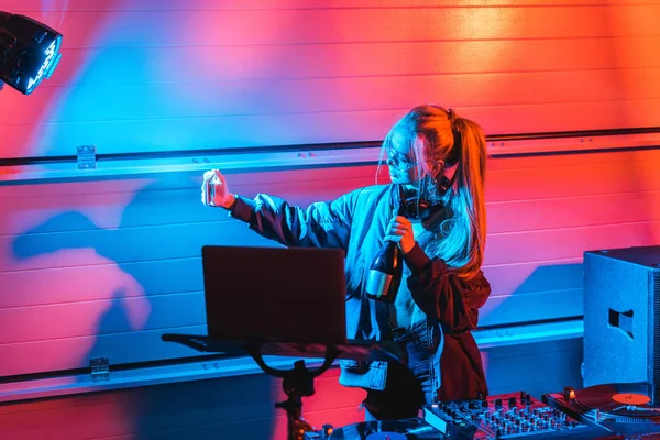 Attraktive blonde dj Frau mit Flasche und Selfie in einem Nachtclub — Stockfoto