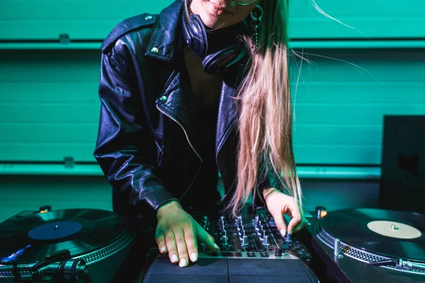 Cropped view of blonde dj girl touching dj mixer in nightclub — Stock Photo