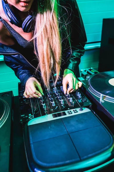 Ausgeschnittene Ansicht eines DJ-Mädchens, das den Equalizer auf einem DJ-Mischpult in einem Nachtclub berührt — Stockfoto