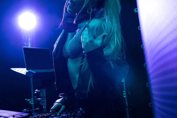 Recortado vista de rubia dj chica de pie cerca dj mixer en nightclub - foto de stock
