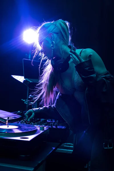 Blonde stylish dj girl touching dj mixer in nightclub — Stock Photo