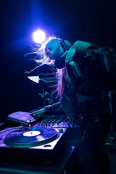 Feliz rubia y elegante dj chica tocando dj equipo en discoteca - foto de stock