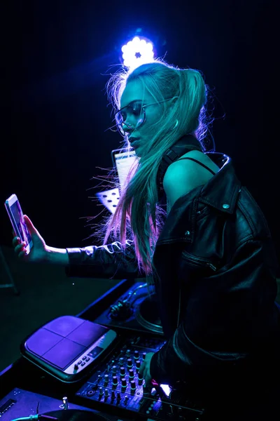 Stylish dj girl touching dj equipment while taking selfie in nightclub — Stock Photo