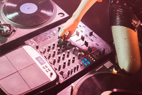 Cropped view of dj girl touching dj equipment in nightclub — Stock Photo