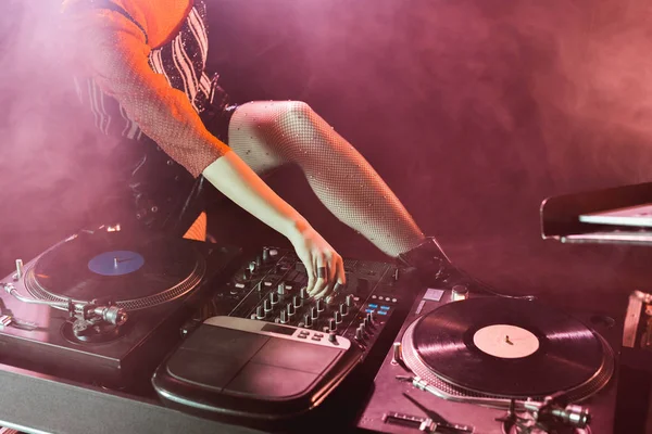 Ausgeschnittene Ansicht von DJ-Mädchen berührt DJ-Mixer in Nachtclub mit Rauch — Stockfoto
