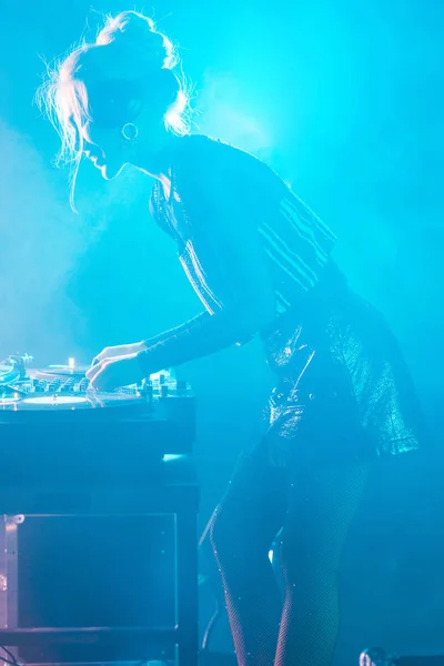 Beautiful dj woman with blonde hair using dj mixer in nightclub with smoke — Stock Photo