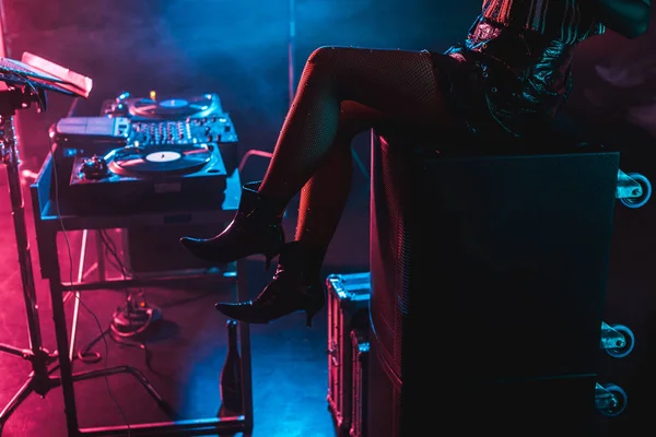 Vista cortada de dj mulher sentado perto de equipamento dj em boate com fumaça — Fotografia de Stock