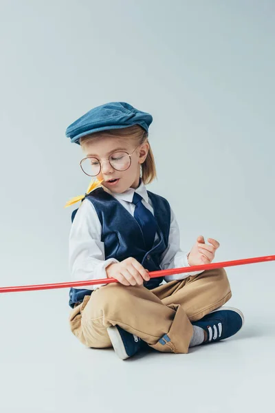 Surprised kid sitting with crossed legs and looking at butterfly — Stock Photo