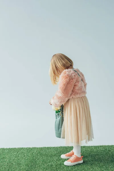 Side view of girl holding bag with white tulips isolated on grey — Stock Photo