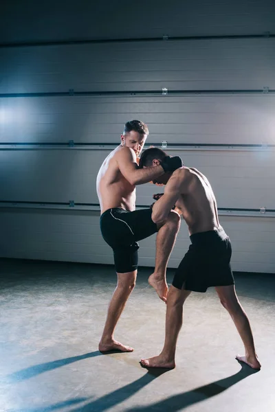 Muscular mma fighter patear oponente deportivo con rodilla - foto de stock