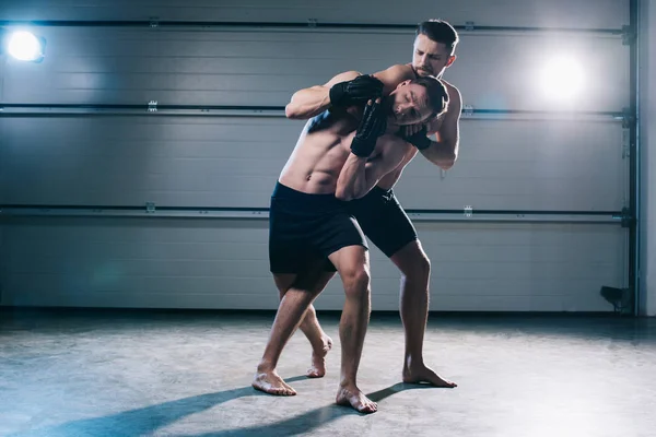 Combattant mma musculaire faisant étranglement à l'adversaire torse nu sportif — Photo de stock