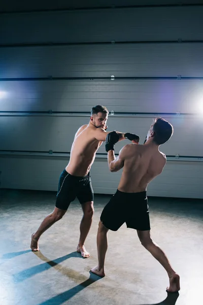 Сильные босые мма-спортсмены сражаются, пока человек бьет другого — стоковое фото