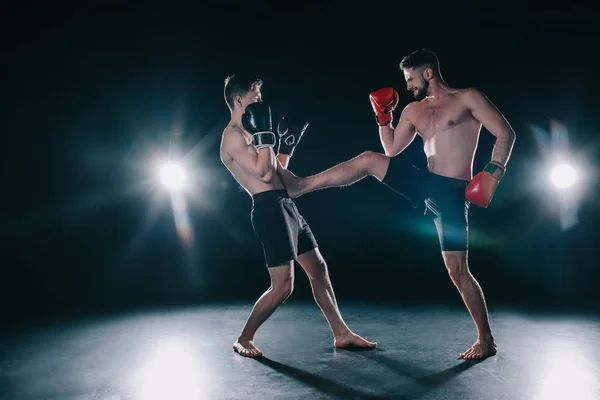 Без сорочки м'язистий боєць в боксерських рукавичках штовхає іншого в торс — стокове фото