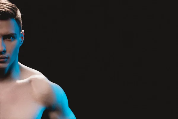 Cropped view of handsome muscular sportsman looking at camera isolated on black — Stock Photo