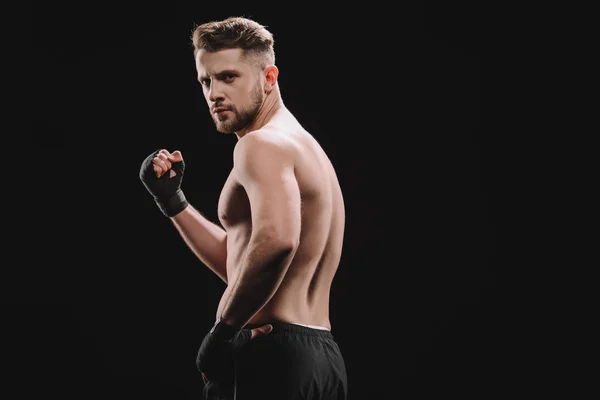 Muscular strong shirtless mma fighter showing fist at camera isolated on black — Stock Photo