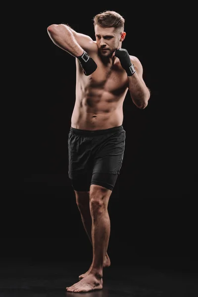Muskulöse MMA-Kämpferin in Bandagen beim Schlag mit dem Ellbogen auf schwarz — Stockfoto