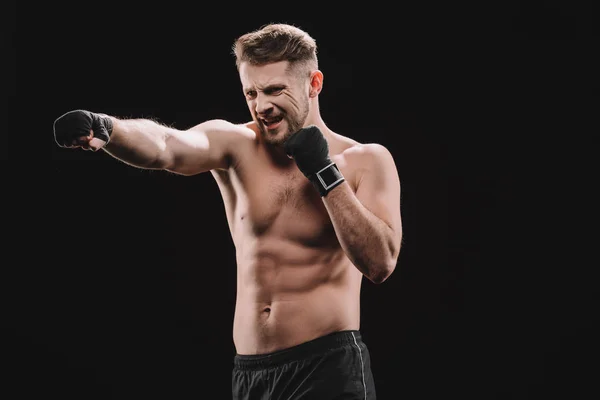 Luchador mma muscular extenuante en vendajes haciendo ponche aislado en negro - foto de stock