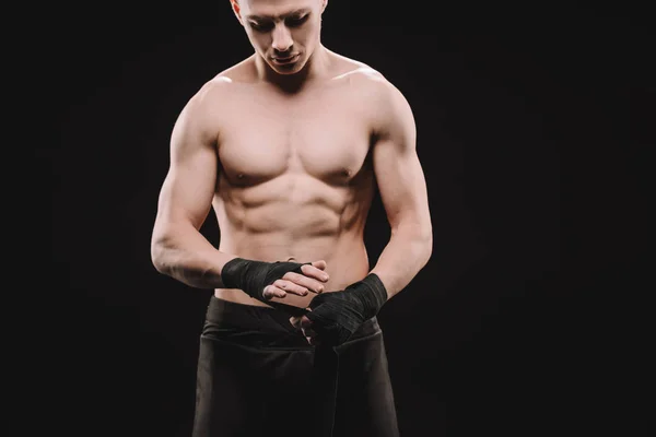 Strong shirtless muscular mma fighter fixing bandages isolated on black — Stock Photo