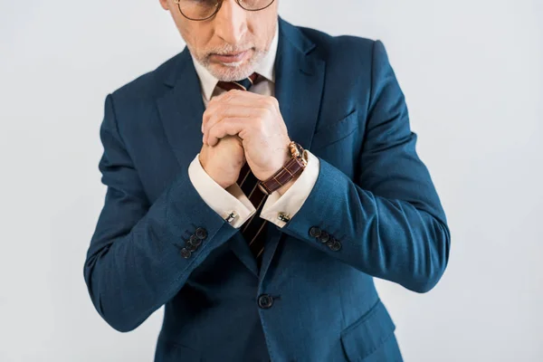 Cropped view of mature businessman in suit standing with clenched hands isolated on grey — Stock Photo