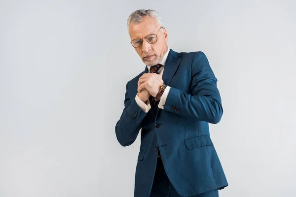 Зрілий бізнесмен у костюмі, що стоїть з зіпсованими руками ізольовано на сірому — стокове фото