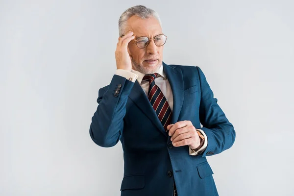 Mature businessman in suit having headache while standing isolated on grey — Stock Photo