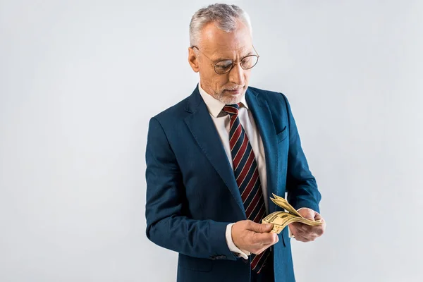 Overhead view of mature businessman in glasses and formal wear holding dollar banknotes isolated on grey — Stock Photo