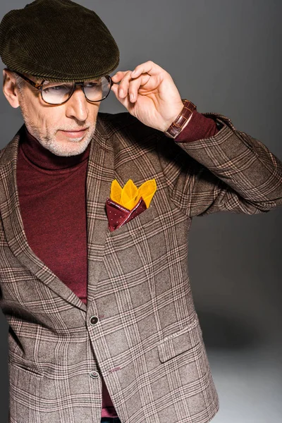 Homem de meia idade na moda tocando óculos em cinza — Fotografia de Stock
