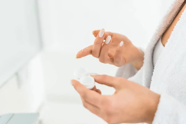 Selective focus of young adult woman holding contact lens in bathroom — Stock Photo