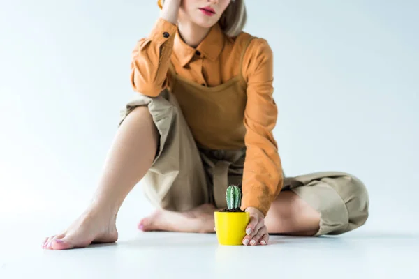 Vista recortada de chica con estilo con planta de cactus en blanco - foto de stock