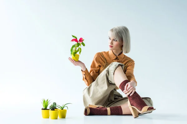 Bella ragazza elegante in posa con vasi di fiori su bianco — Foto stock