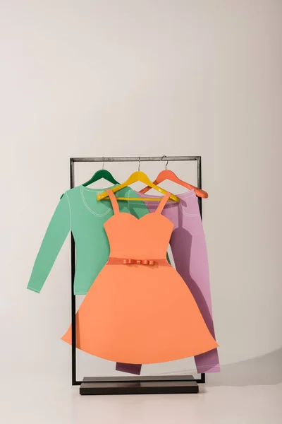 Rack com roupas de papel coloridas em branco — Fotografia de Stock