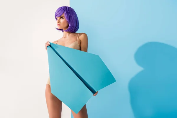 Bella ragazza con i capelli viola in posa con piano di carta su blu e bianco con spazio copia — Foto stock