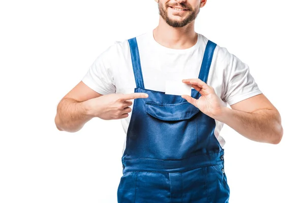 Cropped view of mover in uniform pointing with finger at blank business card isolated on white — Stock Photo