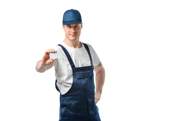 Bonito mover em uniforme olhando para a câmera e segurando cartão de visita em branco isolado em branco com espaço de cópia — Fotografia de Stock